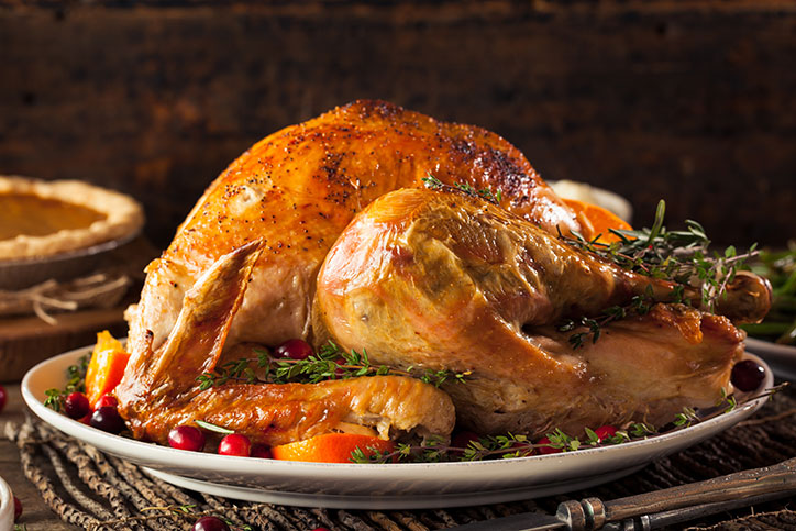 Golden brown baked turkey sitting on a platter.