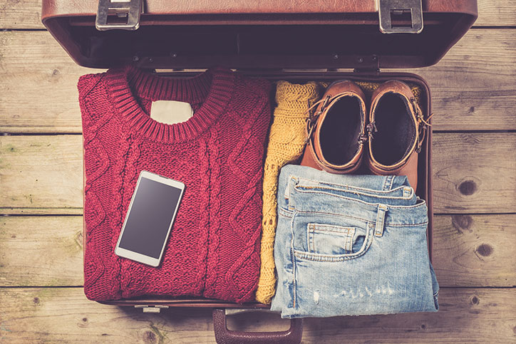 Open suitcase packed with clothing.