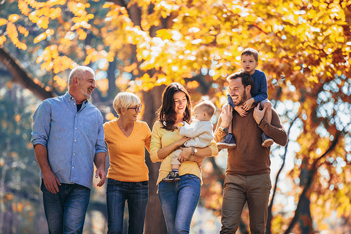 Multi-generation family walking in autumn park
