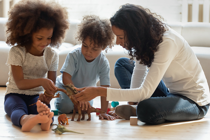 Pleasant black female tutor explaining children interesting facts about dinosaurs