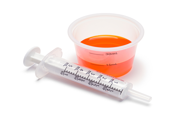 Liquid Medicine in Cup with Oral Syringe.